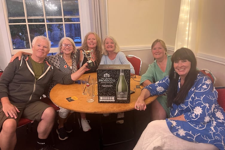 Quiz night winners, Mermaids are Us, with their trophy and case of prosecco.